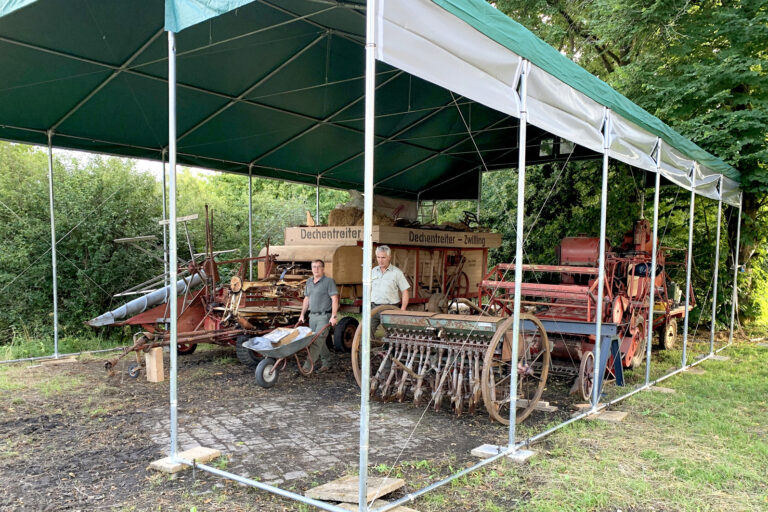 Auf dem Nachbargelände der befreundeten Kyffhäuser-Kameraden hat der Heimatverein Landwirtschaft und Brauchtum Bad Berleburg inzwischen ein beachtliches Zelt errichtet. Darin sollen vorübergehend die größeren Landmaschinen und Geräte untergebracht werden. Sobald der Bau einer historischen Remise auf dem Gemeinschaftsgelände am Sengelsberg durchgeführt werden kann, wird das Zelt wieder abgebaut. Im Bild aktiv bei einem der vielen ehrenamtlichen Einsätze: Christoph Weyand (links) und Klaus Daum. (Foto: Christoph Vetter)