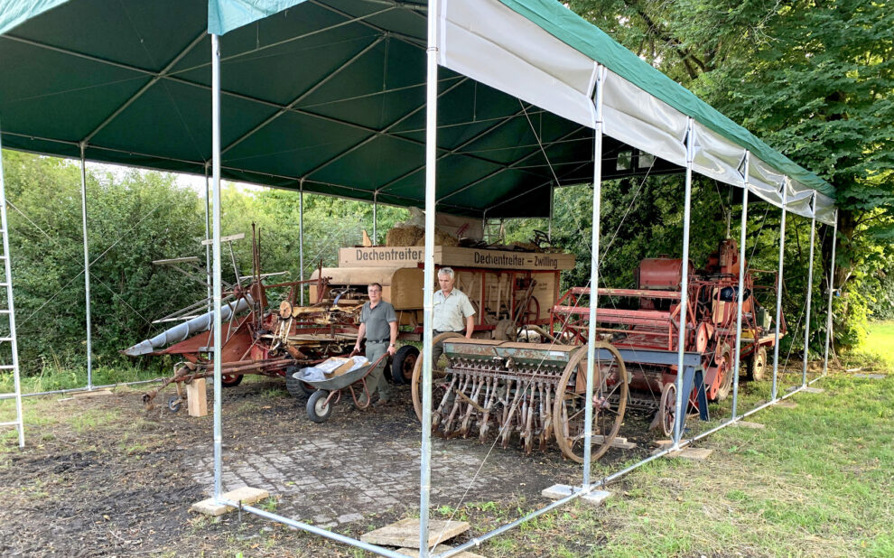 Auf dem Nachbargelände der befreundeten Kyffhäuser-Kameraden hat der Heimatverein Landwirtschaft und Brauchtum Bad Berleburg inzwischen ein beachtliches Zelt errichtet. Darin sollen vorübergehend die größeren Landmaschinen und Geräte untergebracht werden. Sobald der Bau einer historischen Remise auf dem Gemeinschaftsgelände am Sengelsberg durchgeführt werden kann, wird das Zelt wieder abgebaut. Im Bild aktiv bei einem der vielen ehrenamtlichen Einsätze: Christoph Weyand (links) und Klaus Daum. (Foto: Christoph Vetter)