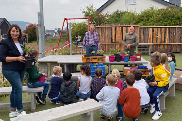 Ihre eigene Eiche können 50 Kinder der Burgfeldschule Bad Berleburg bald pflanzen. Klassenlehrerin Katharina Kuhli (links) freut sich mit den Jungen und Mädchen über die sinnvolle Spende, die Klaus Sonneborn und Friedhelm Kroh jetzt für den Heimatvereins Landwirtschaft und Brauchtum überbrachten. (Foto: Schule)