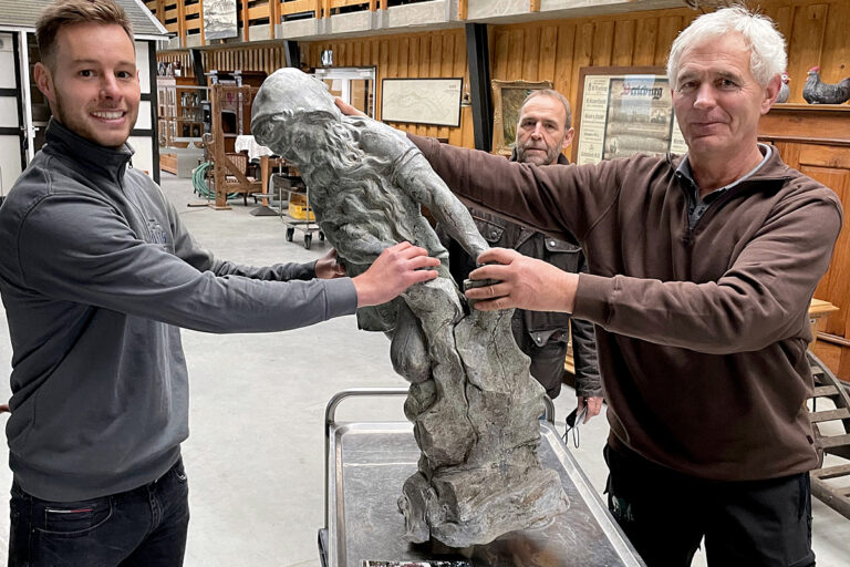 Zum Bild: Metallbauer und Restaurator Felix König (links) übernimmt vom Heimatvereinsvorsitzenden Klaus Daum (rechts) die Brunnenfigur, um sie in seiner Werkstatt in Lüdenscheid genauer unter die Lupe zu nehmen. Im Hintergrund der Finanzexperte und Beirat im Verein, Klaus Sonneborn. (Foto: Heimatverein Landwirtschaft und Brauchtum Bad Berleburg)